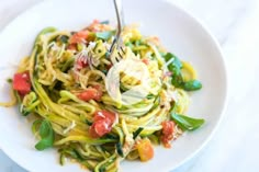 a white plate topped with pasta and veggies