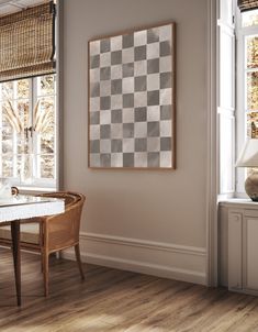 a dining room with a checkered wall and wooden table in front of the window