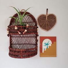 an air plant hanging from the side of a wall next to a heart shaped basket