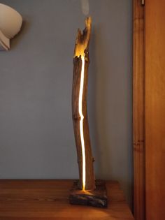 a light that is sitting on top of a wooden table in front of a wall