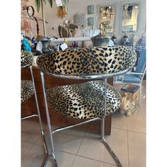 a pair of leopard print chairs sitting on top of a counter next to a mirror