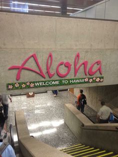 the sign for aloha welcomes travelers to hawaii and is painted with pink flowers