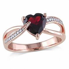 a red heart shaped ring with diamonds on the sides and an arrow in the middle