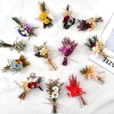 a bunch of dried flowers sitting on top of a white sheet next to a book