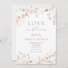 the love in bloom wedding shower card is shown on a marble surface with white and pink flowers