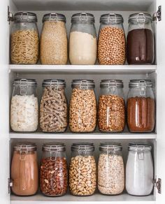 an organized pantry filled with lots of different types of food and cereals in glass jars