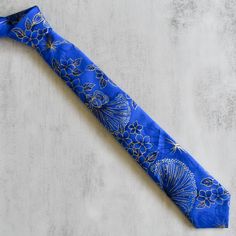 Introducing the Verified Tie - a sophisticated accessory for the refined man. This exquisite tie boasts a striking blue Hawaiian print, complemented by delicate floral detailing and luxurious gold accents. Elevate any outfit with its elegant touch and make a statement of refined taste. Each tie is carefully hand-cut and hand-stitched. Due to the handmade nature and pattern, no two neckties are the same. Size Guide Skinny: 2.5" wideStandard: 3.5" wide Product Details 100% cotton 59" length, tip t Hawaii Hair, Bobby Pin Hairstyles, Accessories Blue, Magnetic Earrings, Coffee Sleeve, Blue Hawaiian, Ipad Sleeve, Stud Set, Hawaiian Print