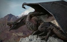 a large black dragon sitting on top of a rock next to a mountain covered in snow