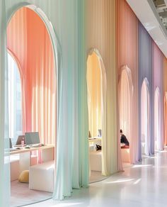 the interior of an office with multiple colored walls and arches on either side of it