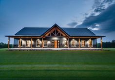 a large house sitting on top of a lush green field next to a tall grass covered field