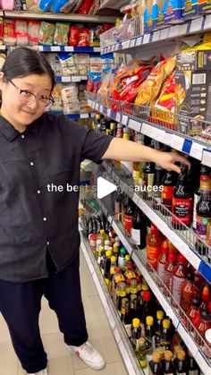 a woman is standing in the aisle of a grocery store with her hand on the shelf