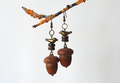 Handmade earrings  with natural acorns that were picked right after they fall off of the oak tree. Every acorn was allowed to dry, cleaned and gently attached to the cap with bronze hooks. I also added some coconut beads and a tiny bird to give it a special touch. These forest earrings will always keep a piece of my touch. They will gently adorn your ears and hold warm wishes inside. Traditionally, acorns are considered as a symbol of good luck and abundance, so these handmade  acorn earrings can be worn as a talisman to give you success and love. A real treasure for all nature lovers; It is really cute, pretty little thing and I hope you will enjoy these talismans as much as I have had to create them ♥ DIMENTIONS & SPECIFICS: ▶MATERIALS: oak acorns from Lithuania, coconut beads, metal det Acorn Cap Earrings, Peter Pan Jewelry, Acorn Jewelry, Botanical Earrings, Tiny Bird, Fall Jewelry, Piece Of Me, Bronze Color, Handmade Earrings