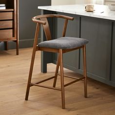 a wooden chair sitting on top of a hard wood floor next to a kitchen counter