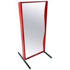 a tall red mirror sitting on top of a metal stand