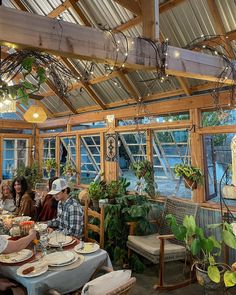 several people sitting at a table in a greenhouse