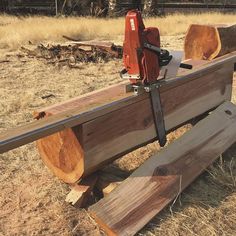 a bench made out of wood with a saw on it's back and two pieces of metal attached to the seat