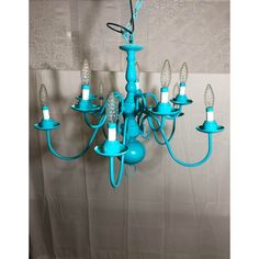 a blue chandelier hanging from the ceiling with five lights on each arm and one light in the middle