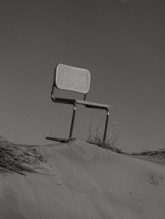 a chair sitting on top of a sandy hill