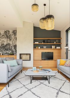 a living room filled with furniture and a flat screen tv mounted on a wall next to a window