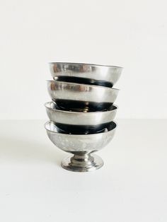 four metal bowls stacked on top of each other