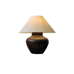 a table lamp with a white shade on it's base and a brown vase