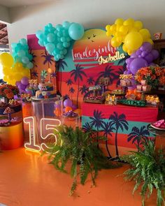 an orange table topped with lots of colorful balloons and desserts on top of it