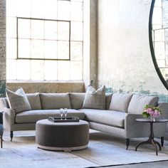 a living room with a sectional couch and round coffee table