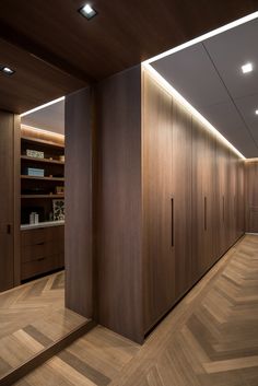 an empty room with wooden flooring and cabinets in the center, along with lights on either side