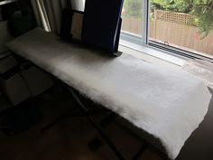 an ironing board sitting in front of a window