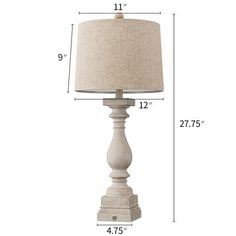 a white lamp with a beige shade on it's side and measurements for the base