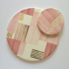 two pink and gold plates sitting on top of each other