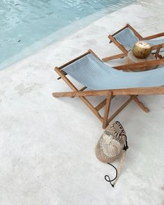 a chair and hat sitting next to a swimming pool