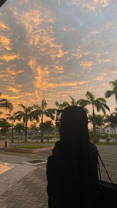 a woman is looking at the sky with palm trees in the backgroung