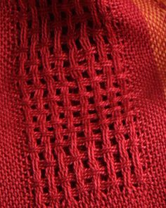 an orange and red knitted cloth with holes in it