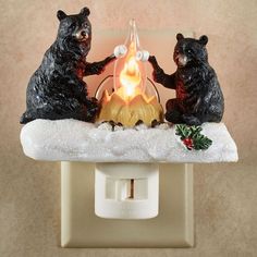 two black bears sitting next to each other on top of a white light switch cover