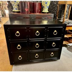 a black dresser with gold handles and knobs on it's drawers in a store