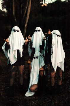 three women dressed in white and black are posing for the camera with their hands up