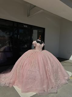 a pink ball gown on display in front of a building