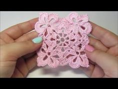 someone is holding a pink crochet doily in their left hand and the other hand is holding it