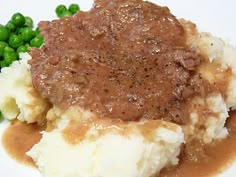 mashed potatoes and gravy with peas on the side