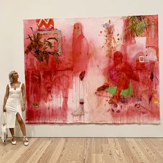 a woman standing in front of a painting on the wall next to a wooden floor