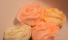 three pink and yellow roses sitting on top of a white countertop next to each other