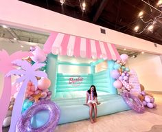 a woman sitting on top of an inflatable couch next to balloons and palm trees