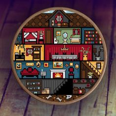 a cross - stitch pattern on a wooden hoop with a house in the middle and lots of windows