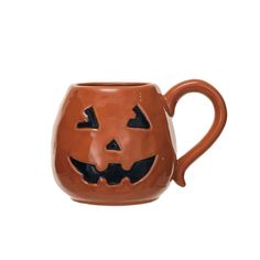 a ceramic mug with a pumpkin face on it