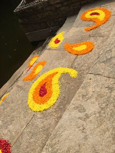 flowers laid out in the shape of numbers on stone steps next to body of water