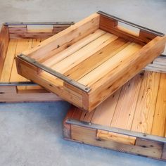 three wooden trays sitting on top of each other in the middle of a floor