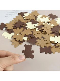 a person holding a piece of brown and white paper with a bear cut out on it