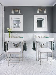 two sinks and mirrors in a bathroom with white tiles on the floor, along with gray walls