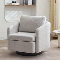 a white chair sitting on top of a hard wood floor next to a book shelf